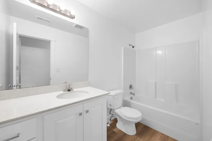 White vanity with a light-toned countertop, integrated sink, and brushed nickel faucet