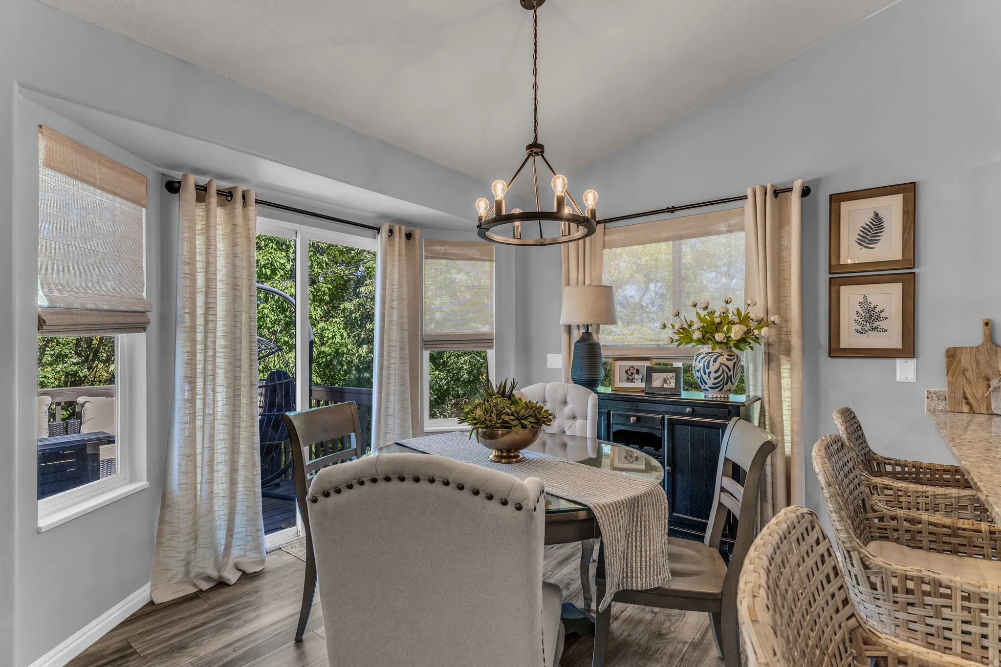 Dining area featuring wood-finish flooring, a contemporary chandelier, and a sliding glass door