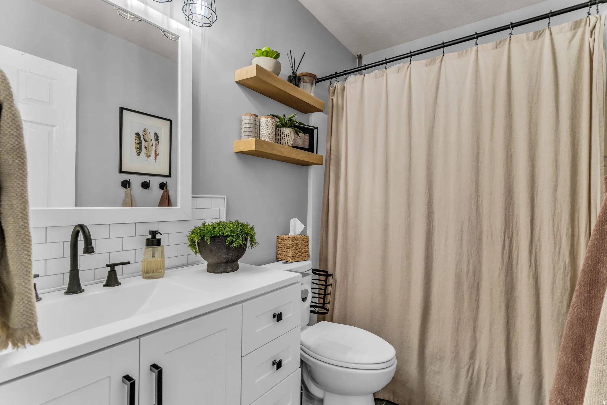 White vanity with black hardware, integrated sink, and dark bronze faucet