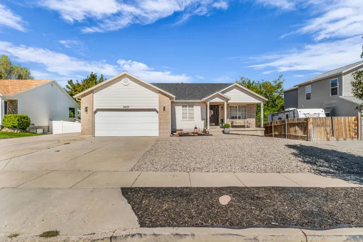 Single-story residence featuring a covered front porch, attached garage, and a gravel front yard