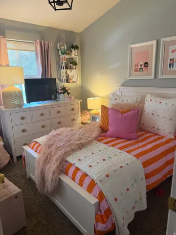 Recessed window with drapes, wall-mounted shelving, and a ceiling-mounted light fixture