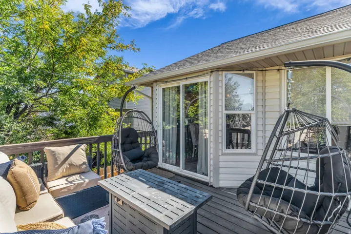 Outdoor deck with wood-finish flooring, white siding, and a sliding glass door