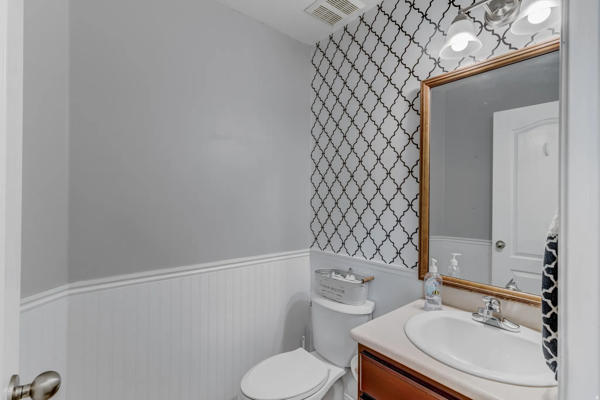 Vanity with an integrated sink, framed mirror, and two-light fixture