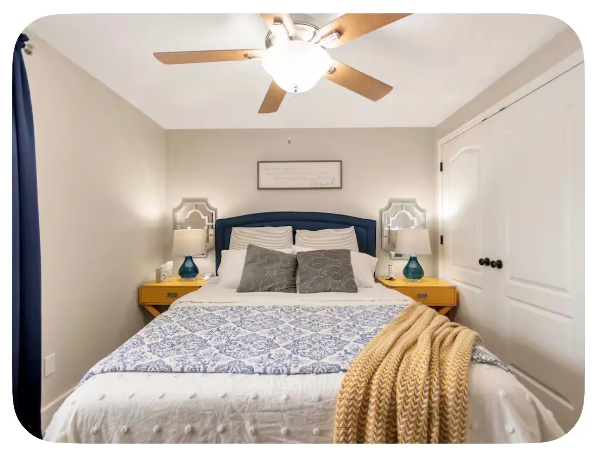 Ceiling fan with light fixture, paneled interior door, and light-toned walls