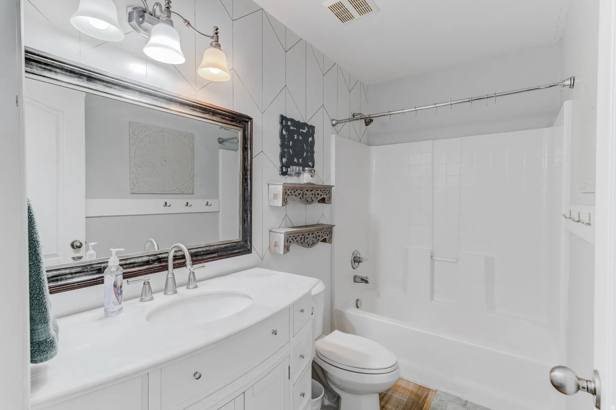 White vanity with an integrated sink, brushed nickel faucet, and a large framed mirror