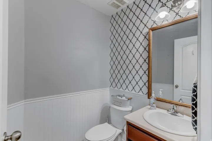 Vanity with an integrated sink, framed mirror, and two-light fixture