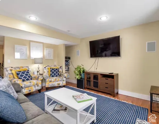 Recessed ceiling lighting, wood-finish flooring, built-in wall speakers, and a media console