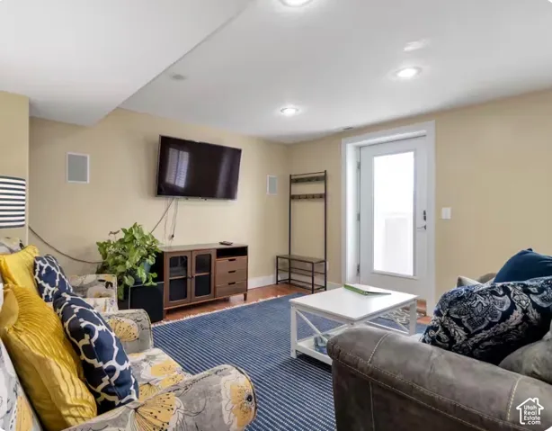 Recessed lighting, wood-finish flooring, white trim, and a white door with frosted glass