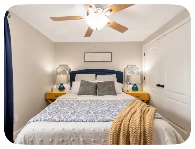 Ceiling fan with light fixture, paneled interior door, and light-toned walls