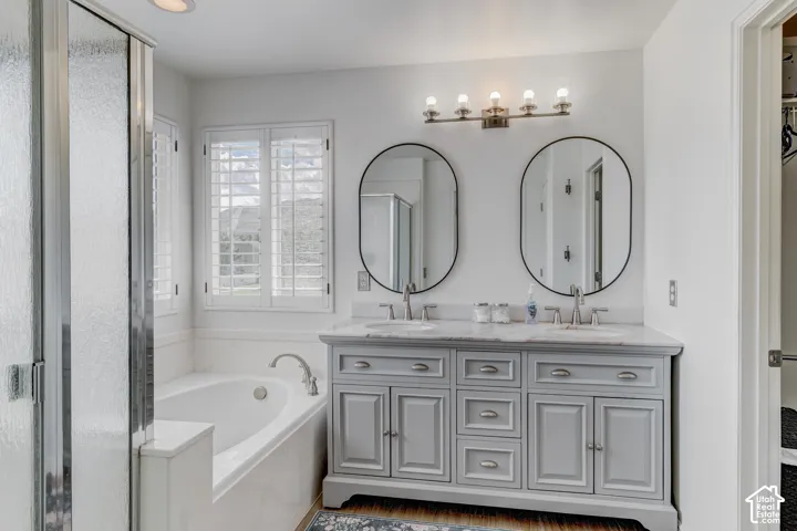 Dual vanity with an integrated countertop, oval mirrors, and brushed nickel fixtures