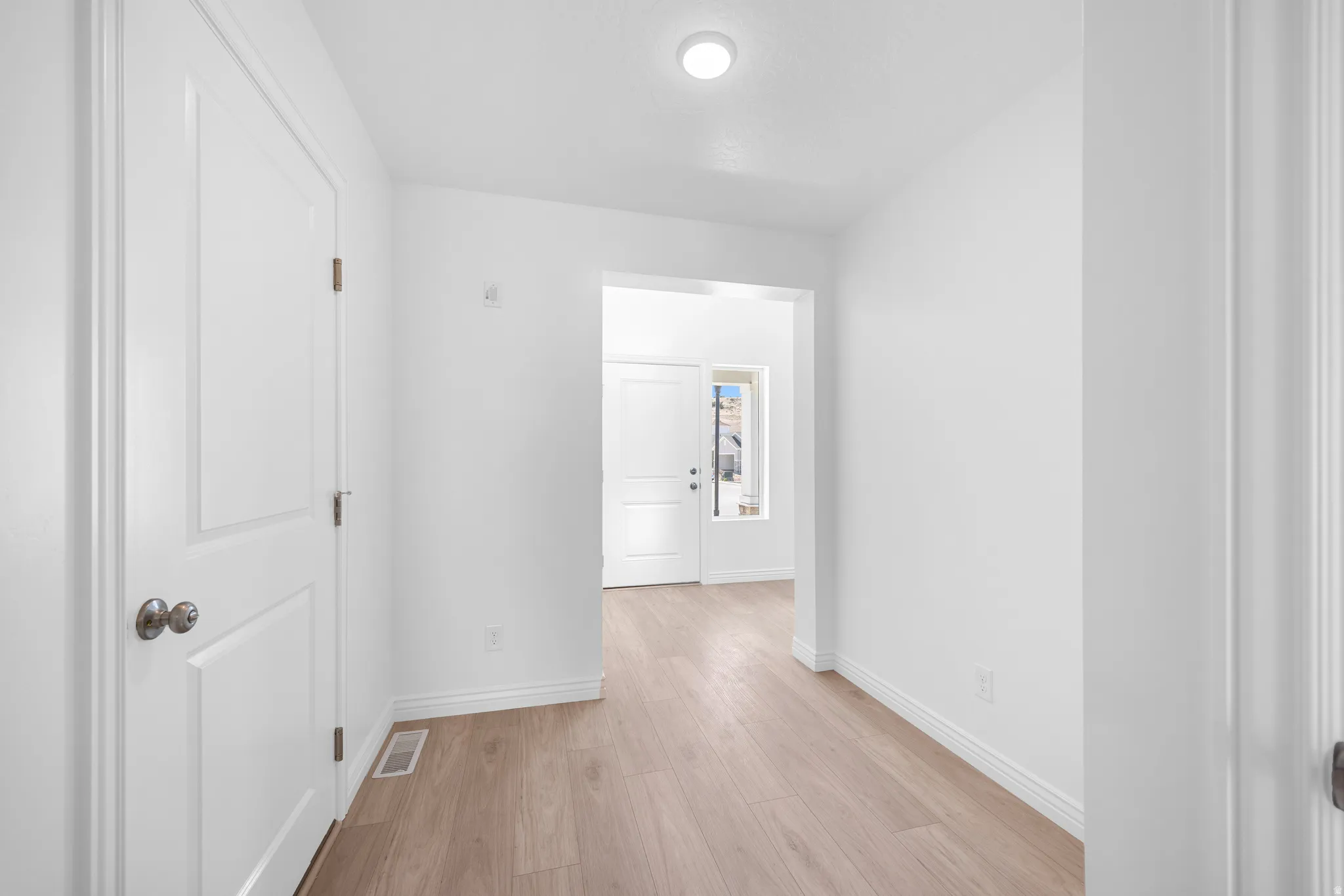 Entryway featuring wood-finish flooring, recessed ceiling light, white walls, and white trim