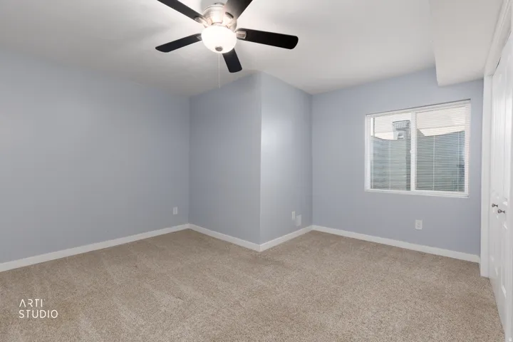 Carpeted flooring, ceiling fan with integrated lighting, single window, and white trim