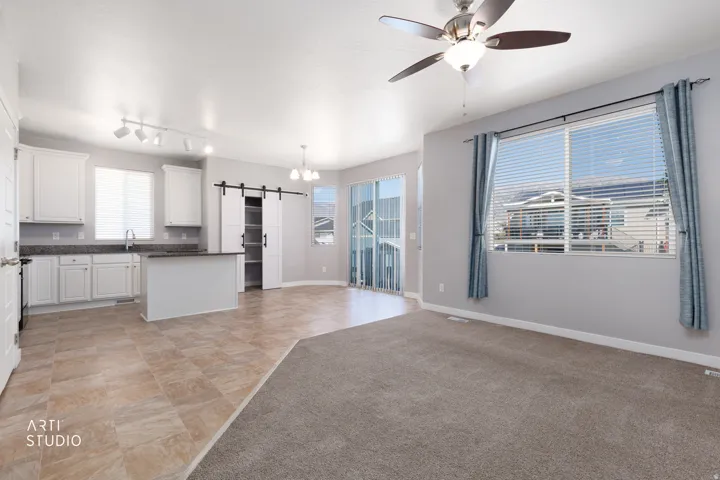 Kitchen featuring white cabinetry with dark countertops, a central island, and tile flooring