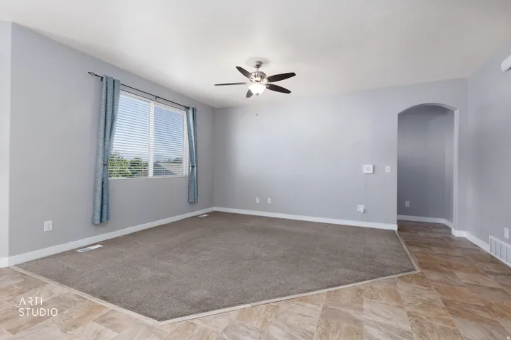 Wall-to-wall carpeting, recessed window, arched doorway, and ceiling fan with lighting
