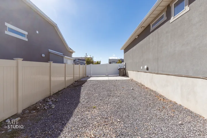 Gravel ground cover with a perimeter vinyl fence and concrete pad