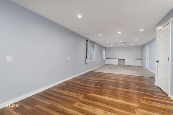 Expansive interior with wood-finish flooring, recessed lighting, and a neutral color palette