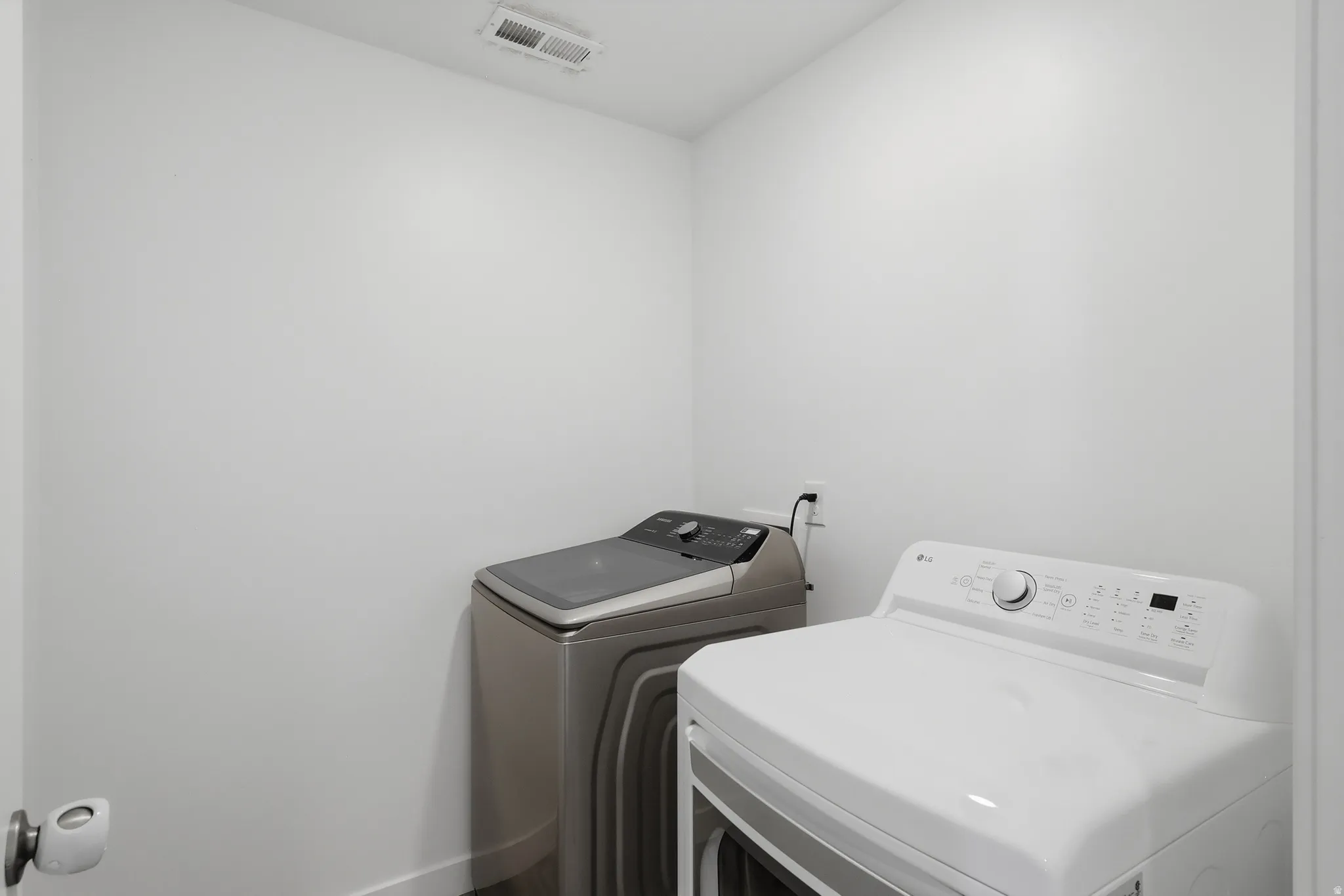 Laundry area with white walls and modern appliances