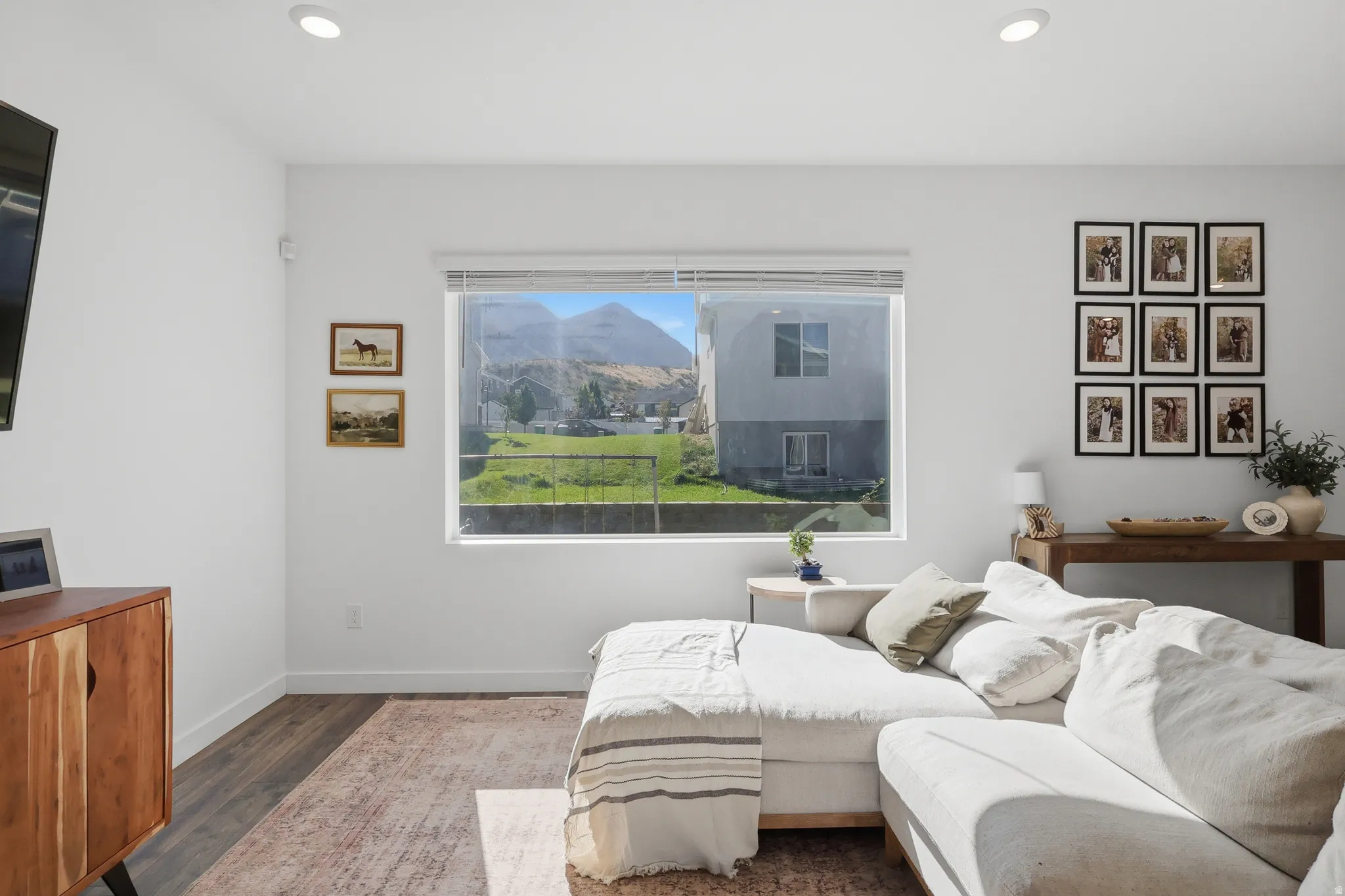 Recessed lighting, wood-finish flooring, and a large window with mountain scenery