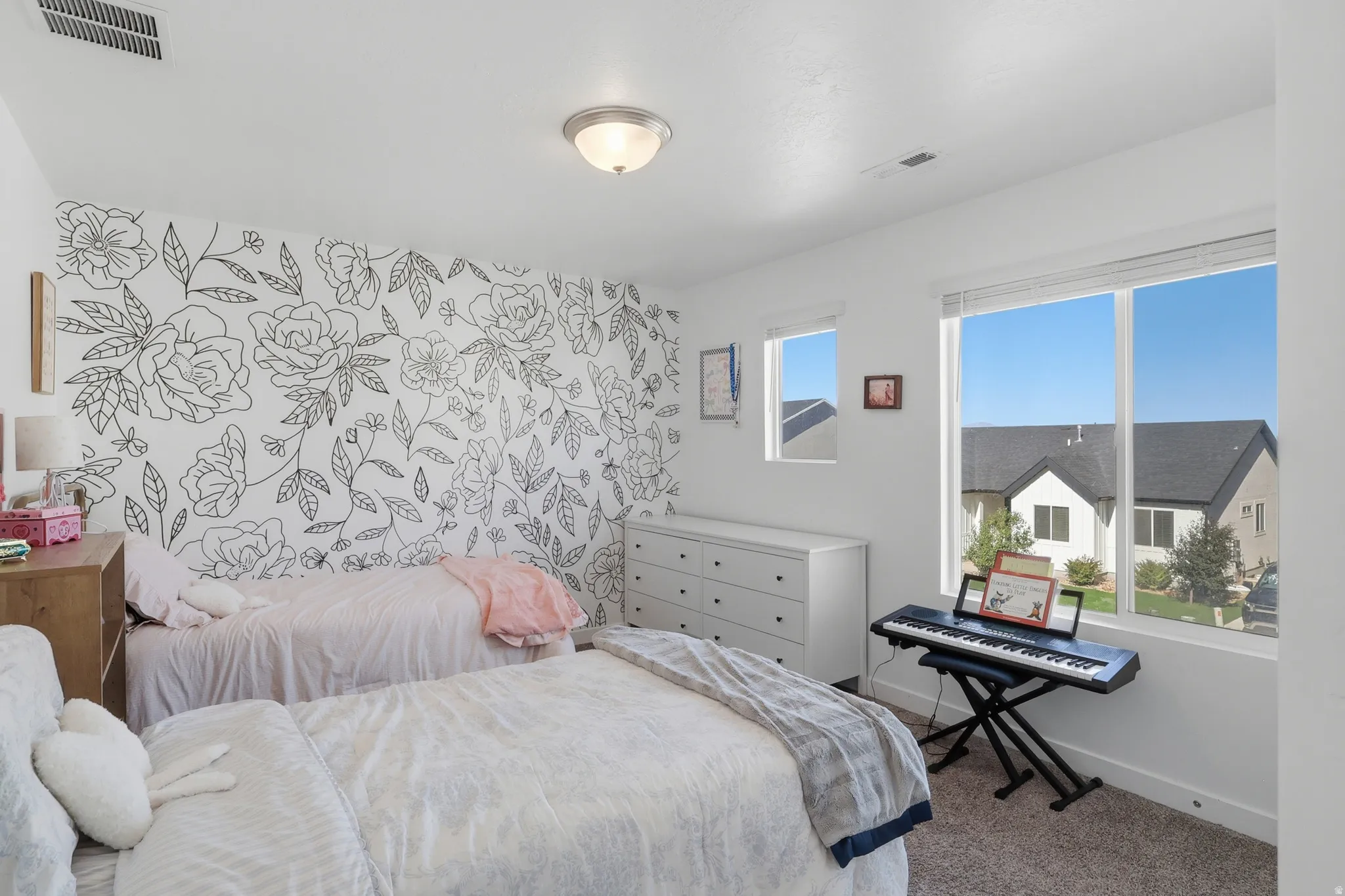 White walls with a floral accent wall, recessed lighting, and large windows