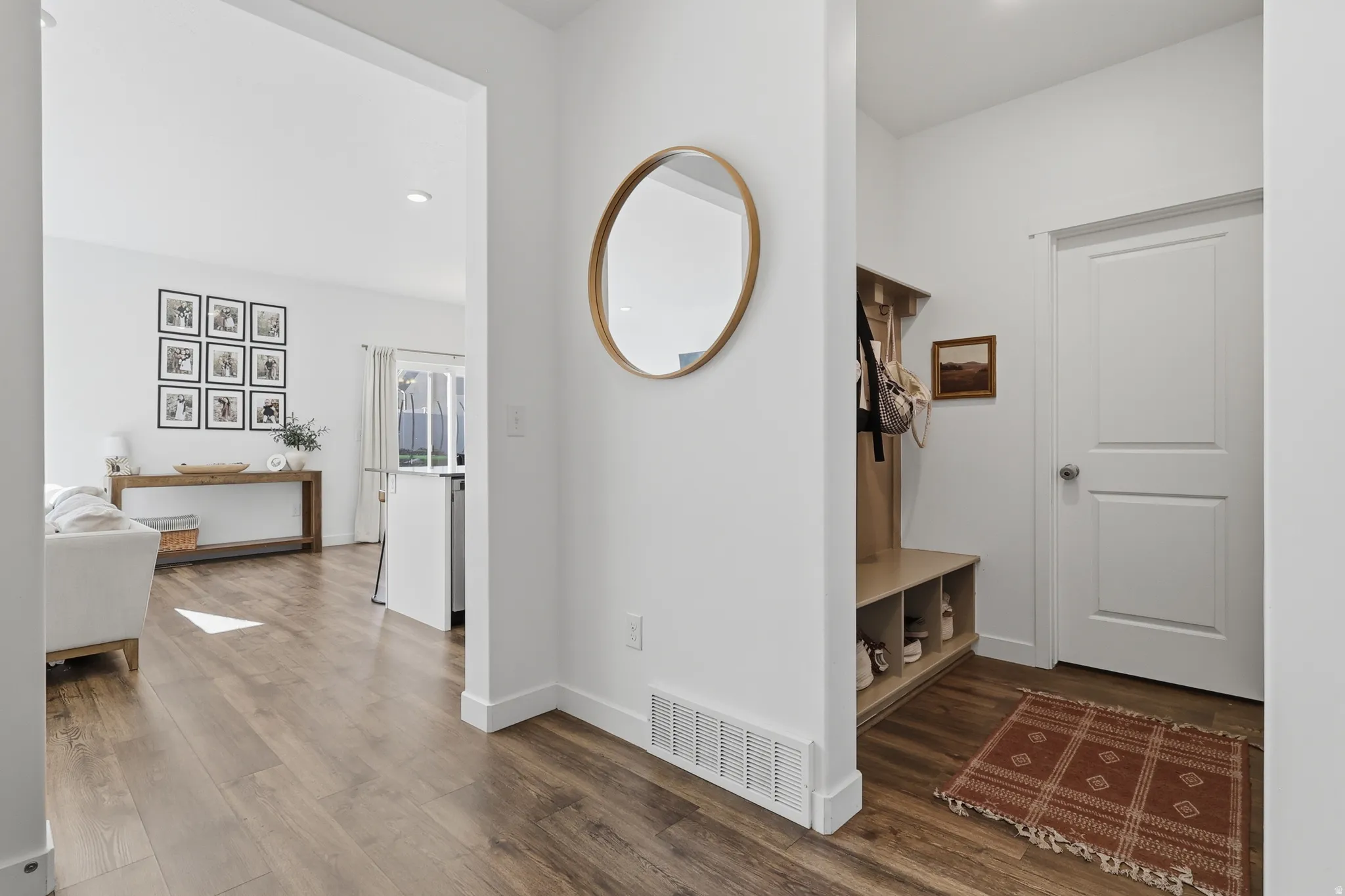 Wood-finish flooring throughout, white walls, and recessed lighting