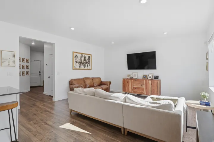 Recessed lighting, wood-finish flooring, white walls, and a window providing natural light