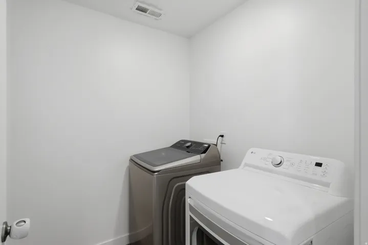 Laundry area with white walls and modern appliances