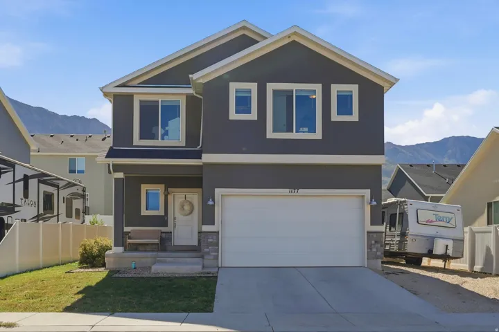 Two-story exterior with a gray facade, white trim, and a two-car garage