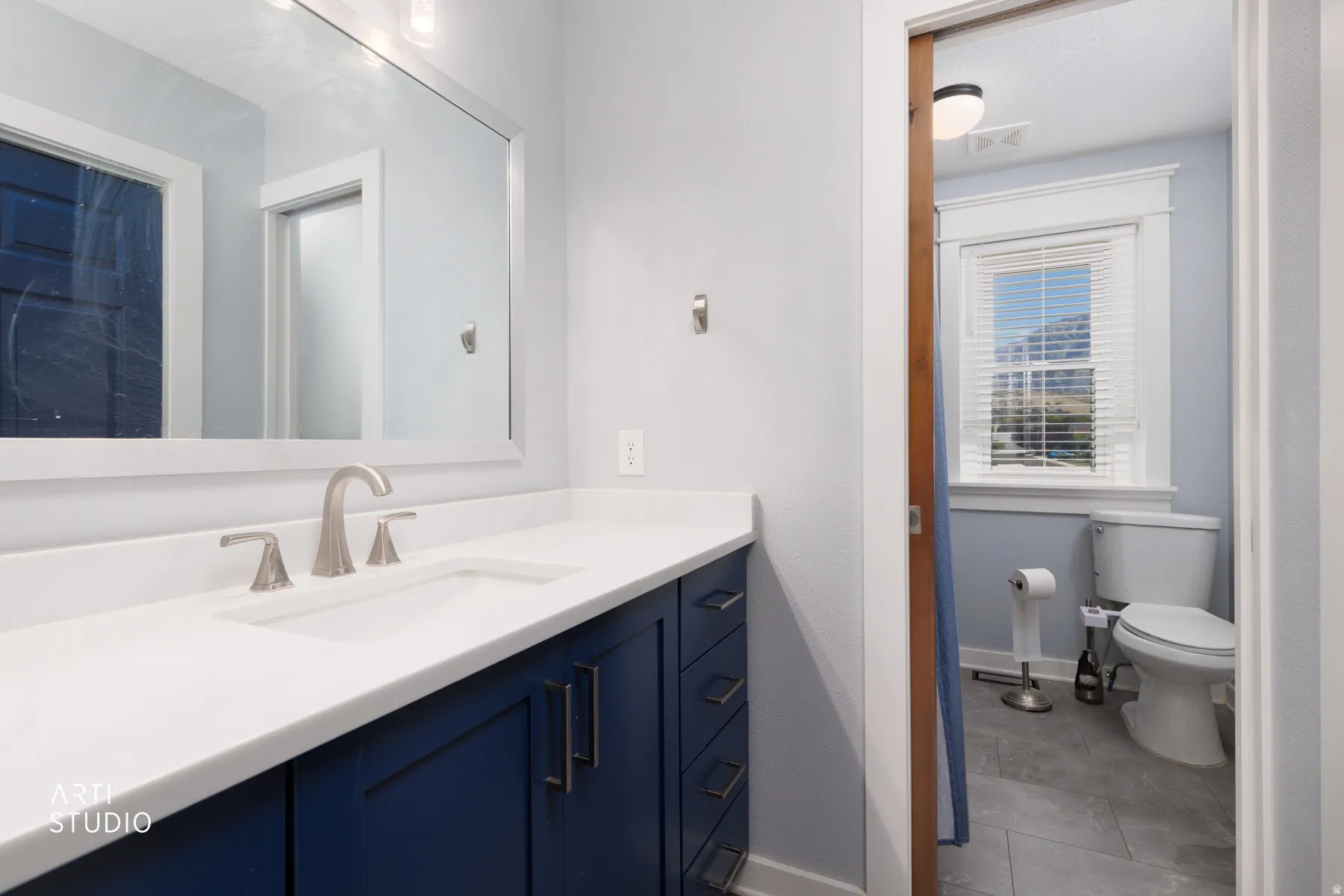 Transitional vanity with a white countertop, undermount sink, and brushed nickel faucet