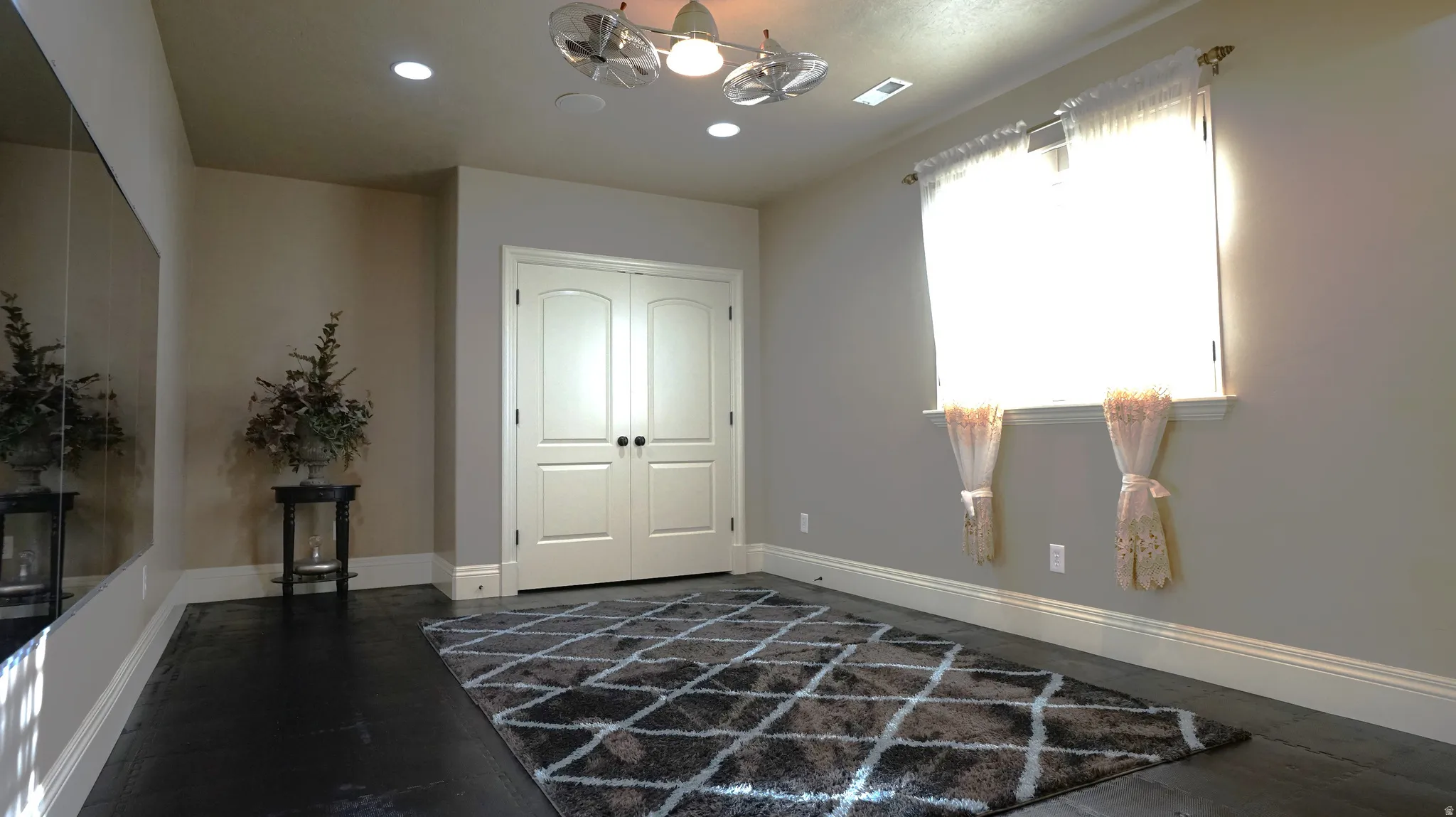 Dark wood-finish flooring, recessed lighting, and a ceiling fan with multiple heads