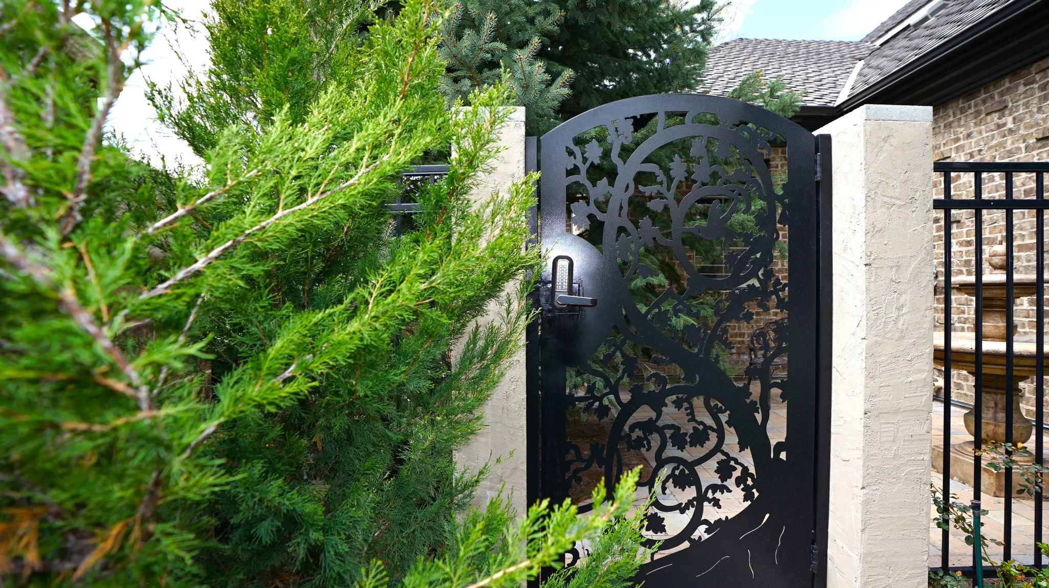 Decorative wrought iron gate featuring an intricate tree design