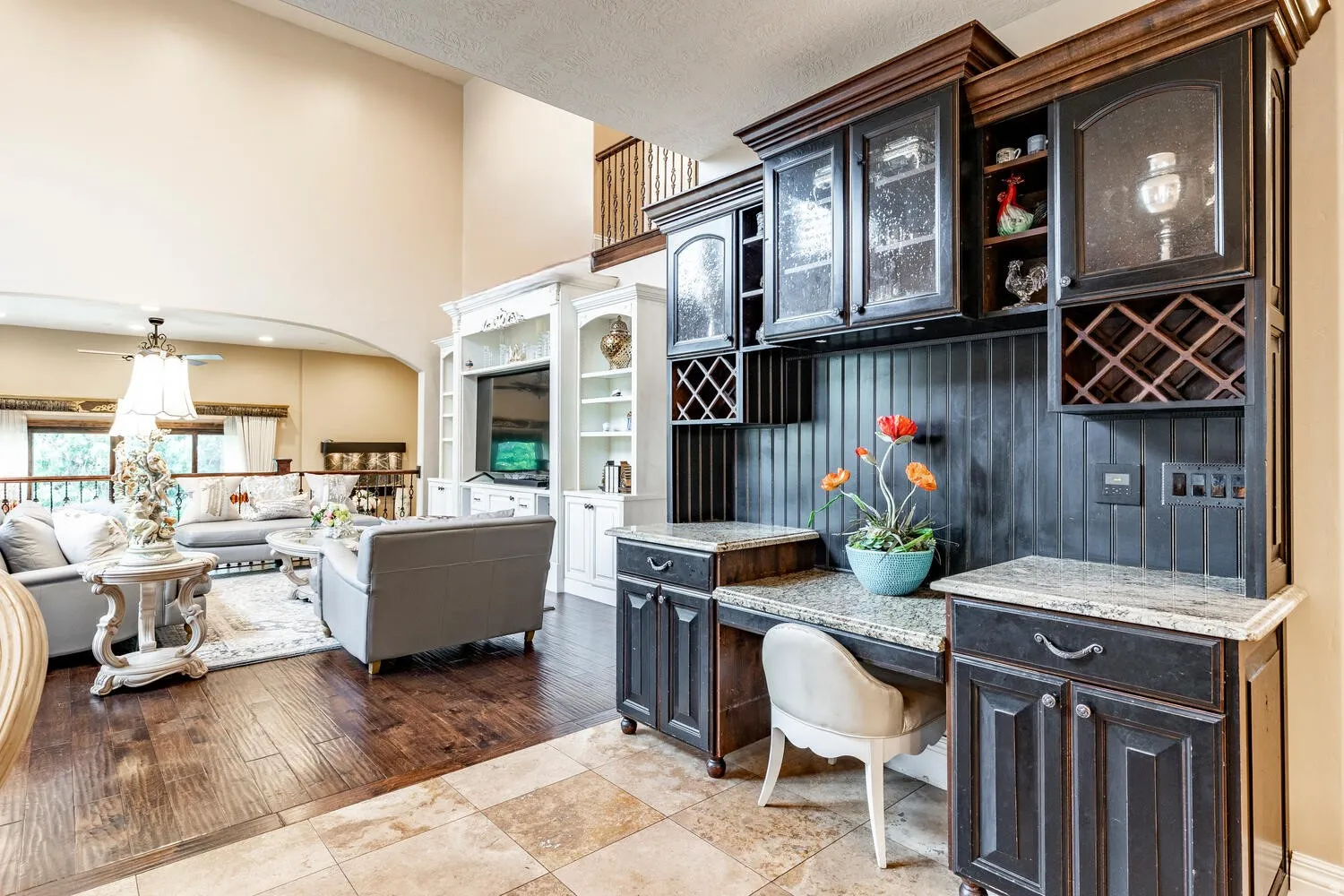Built-in cabinetry with glass-front uppers, integrated wine racks, and granite countertops