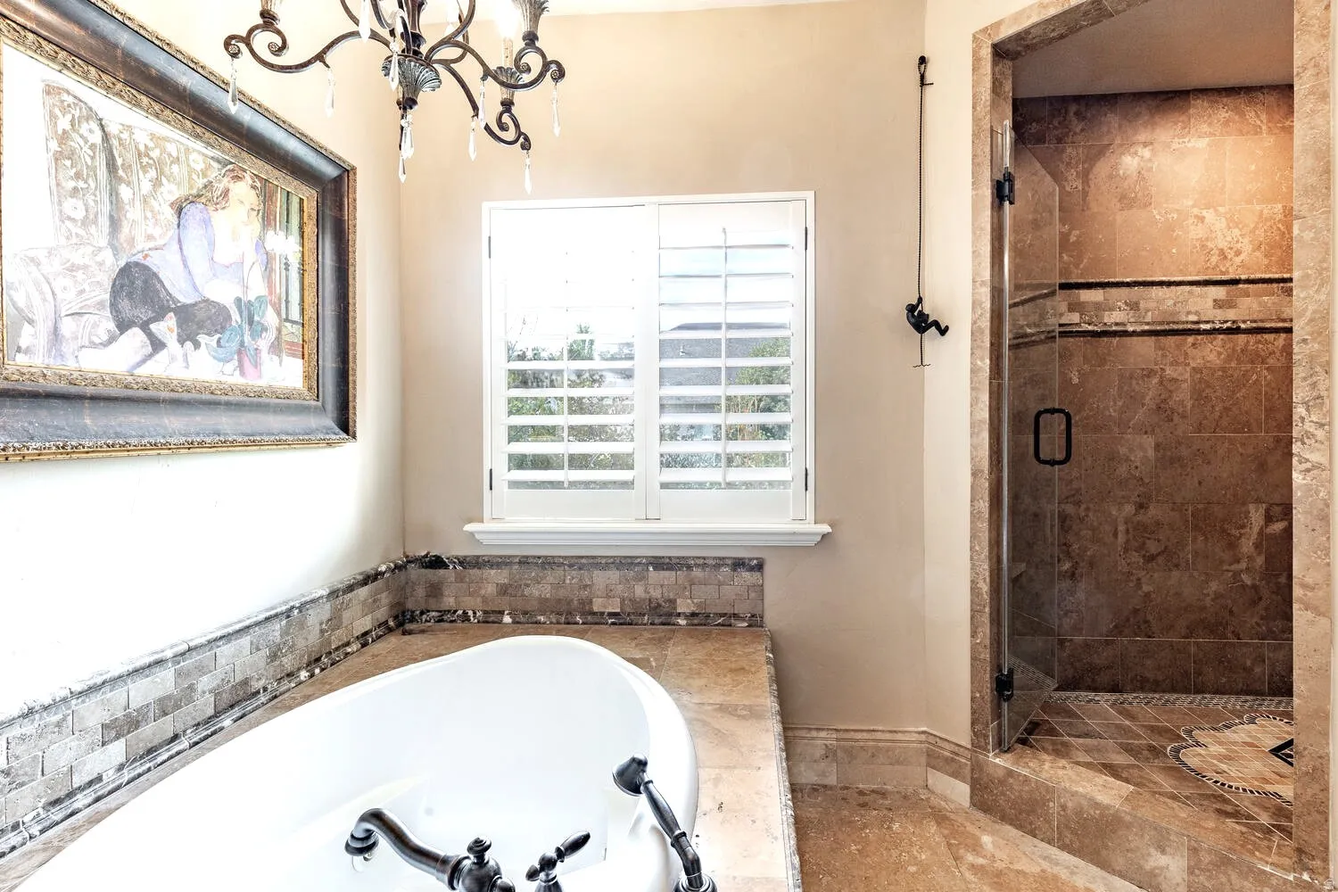 Freestanding bathtub with dark bronze fixtures, adjacent to a walk-in shower with glass enclosure
