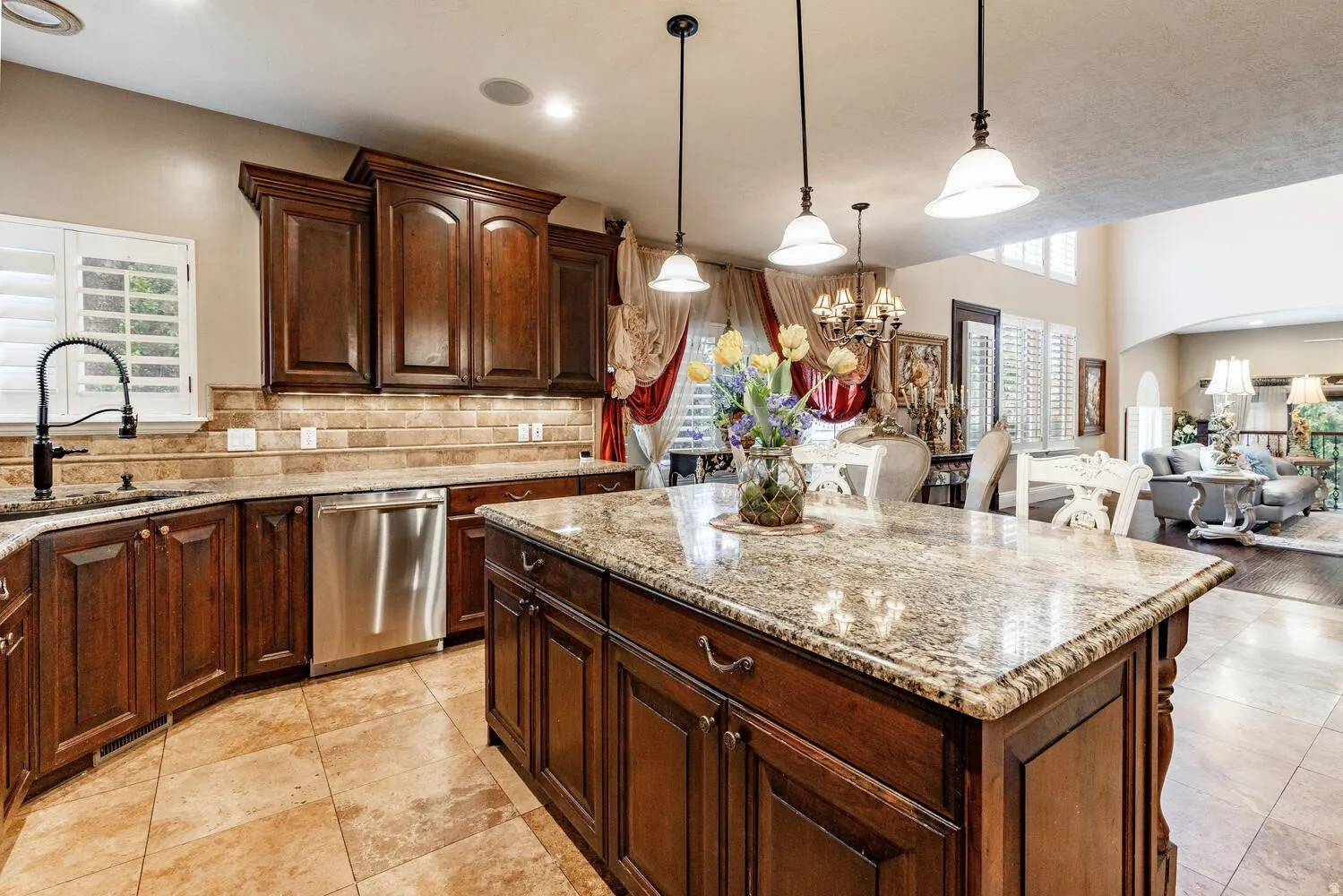 Kitchen featuring a central island with a granite countertop, dark wood-finish cabinetry, stainless steel dishwasher, tile flooring, and recessed lighting