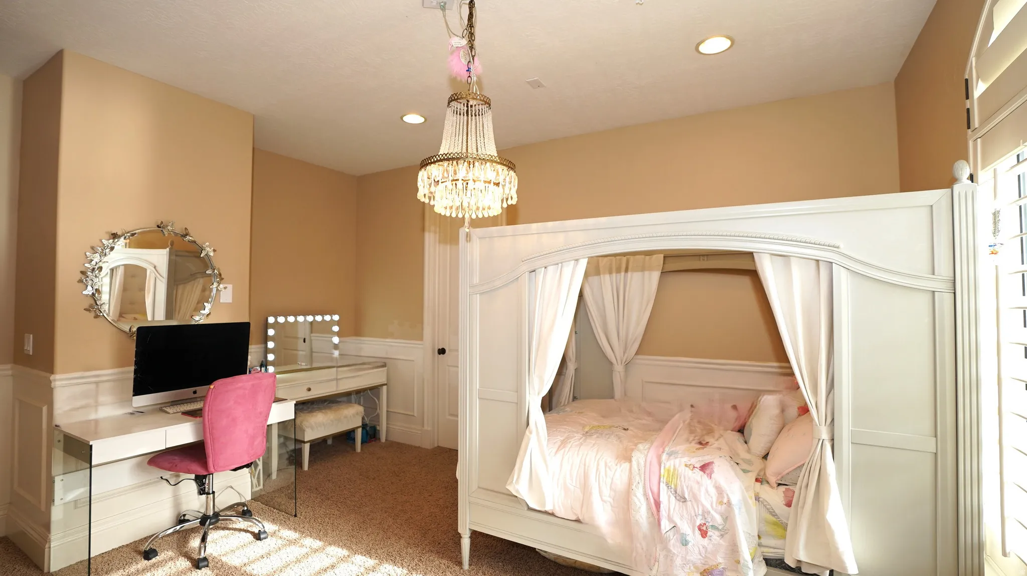 Recessed ceiling lighting, decorative chandelier, wainscoting, plantation shutters, and carpeted flooring