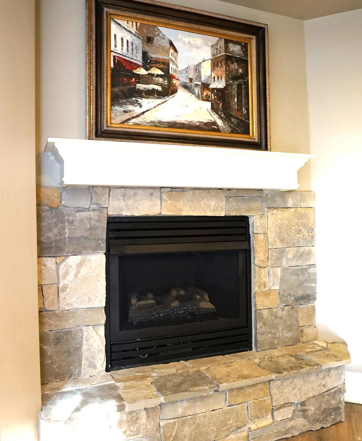 Stone-surround fireplace with a black insert and a white mantel