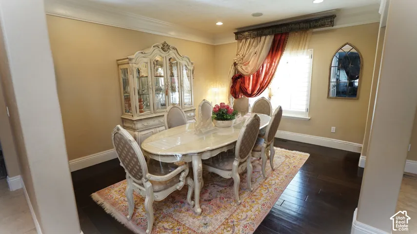 Dark wood-finish flooring with a light wall color and white crown molding