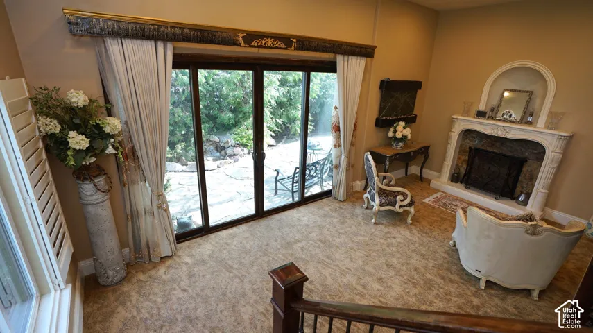 Arched fireplace with decorative mantel, glass slider doors, and shuttered window