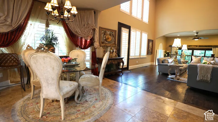Two-story living area with arched entry, hardwood flooring, and abundant natural light