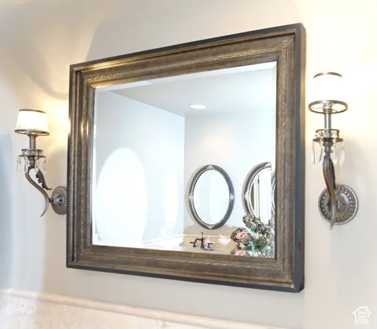 Rectangular framed mirror with ornate sconces featuring crystal accents