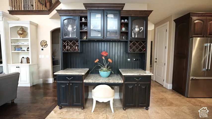 Built-in cabinetry with glass-front uppers, an integrated wine rack, and a beadboard backsplash