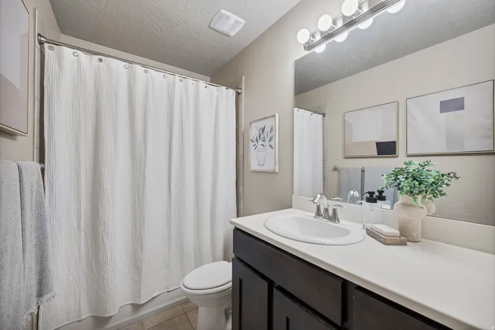 Bath 2. Vanity featuring a white countertop, undermount sink, and dark wood-finish cabinetry