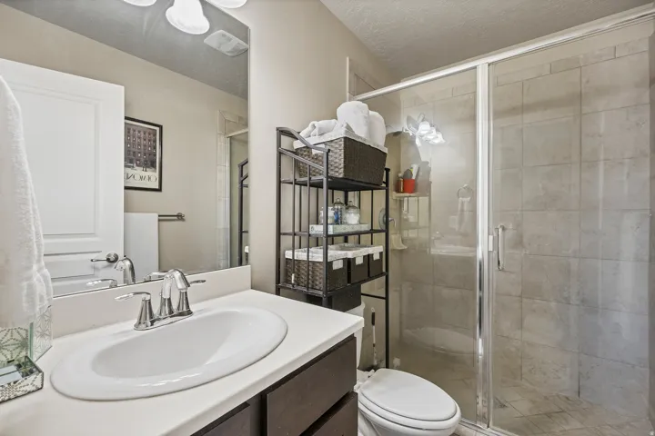 Bath 3. Vanity with an integrated sink, polished chrome faucet, and dark wood-finish cabinetry