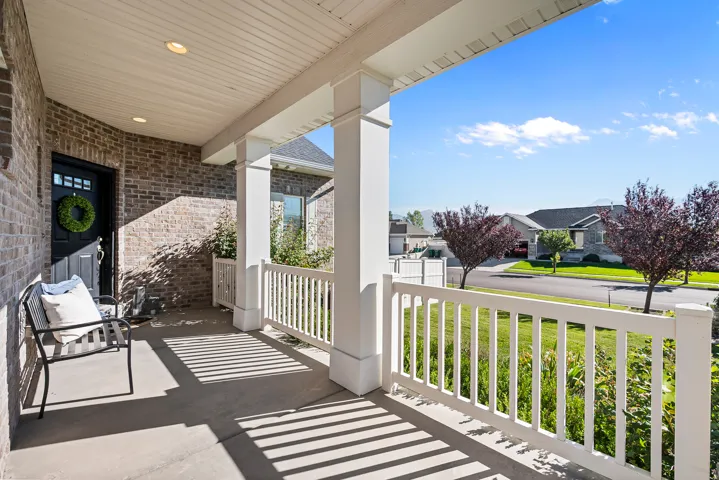 Brick exterior with white porch columns, white railing, and a covered porch