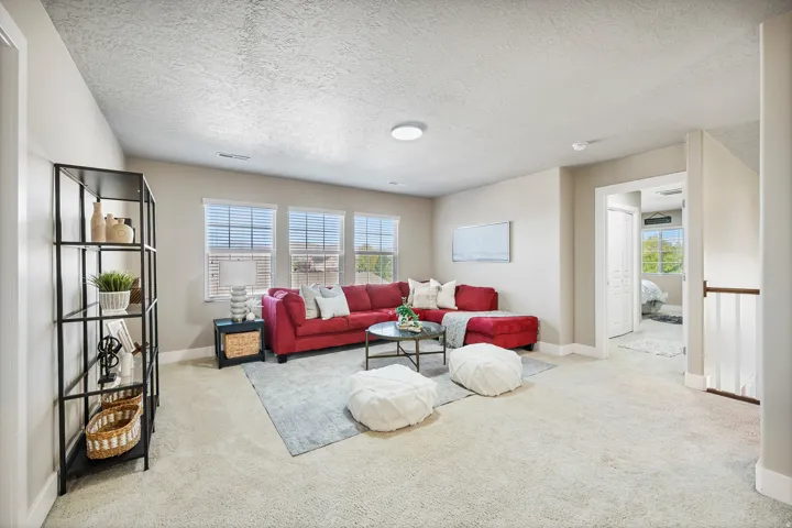 Recessed lighting, light-toned carpeting, multiple windows with blinds, and white trim accents