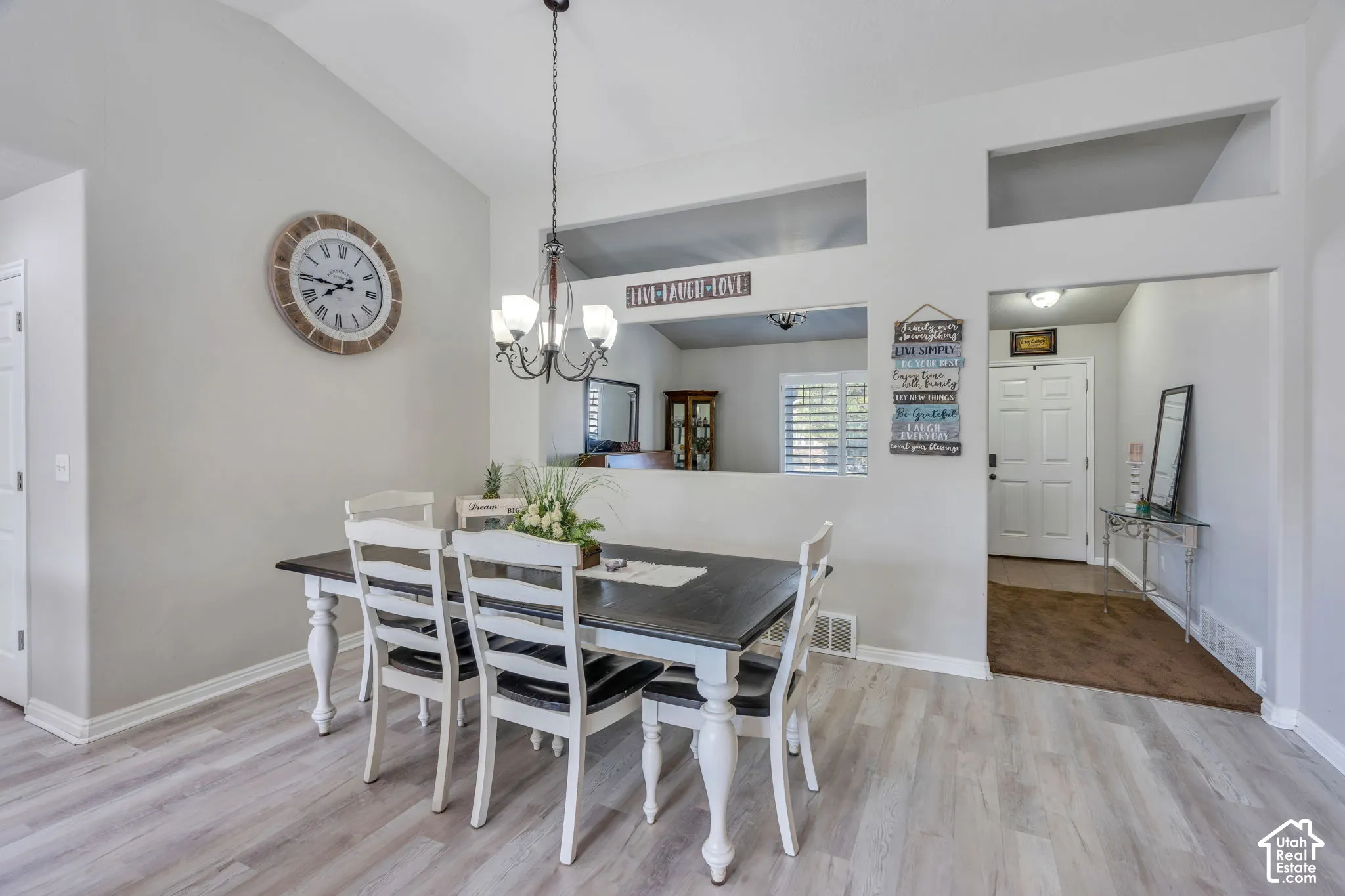 Vaulted ceilings with a chandelier, wood-finish flooring, and recessed wall cut-outs