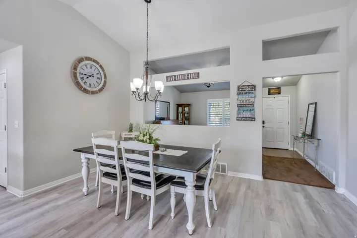 Vaulted ceilings with a chandelier, wood-finish flooring, and recessed wall cut-outs