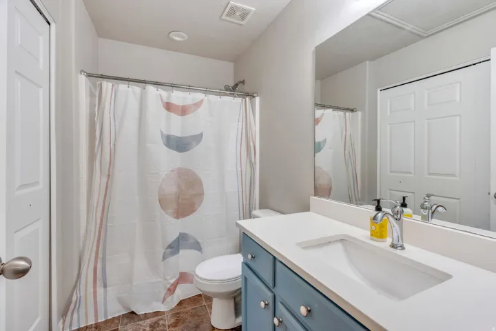 Vanity with light-colored countertop, integrated sink, and chrome faucet