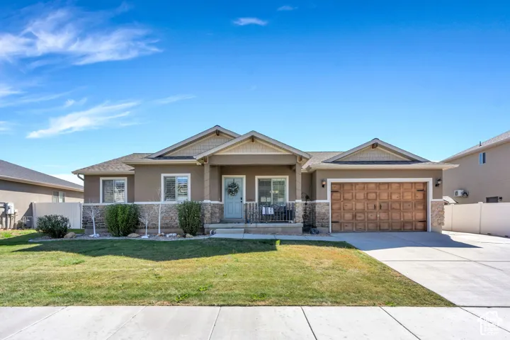 Stucco exterior with stone accents, covered front porch, attached 3 car garage and concrete driveway
