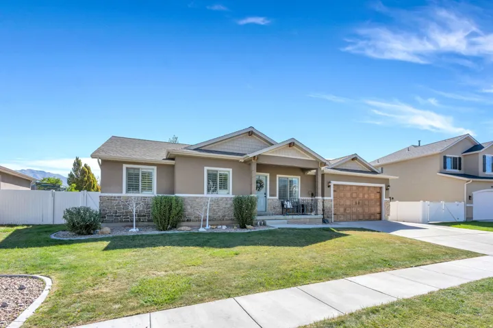 Curb appeal featuring a stone veneer facade, covered porch, attached 3 car garage and a concrete driveway