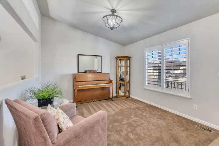 Vaulted ceiling, white walls, and a window with white plantation shutters